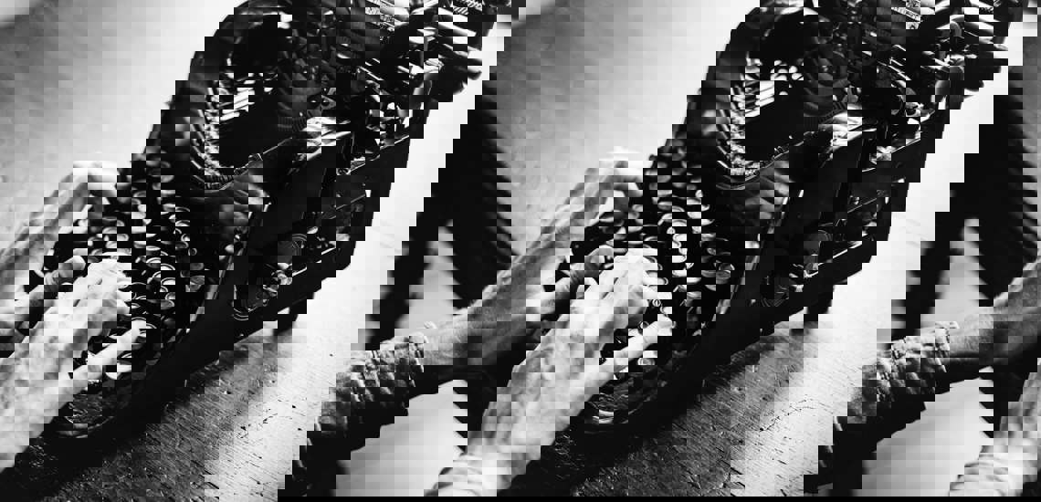 Black and White photo of hands using typing machine